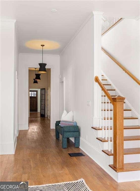 629 Hansell St SE, Atlanta, GA 30312 - hallway with wood finished floors, stairway, baseboards, and ornamental molding