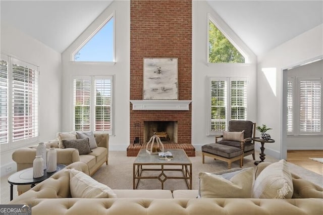 living area featuring high vaulted ceiling, a fireplace, and baseboards