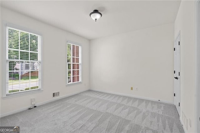 carpeted empty room featuring healthy amount of natural light and baseboards