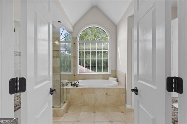 full bathroom with a shower stall, a garden tub, tile patterned floors, and lofted ceiling