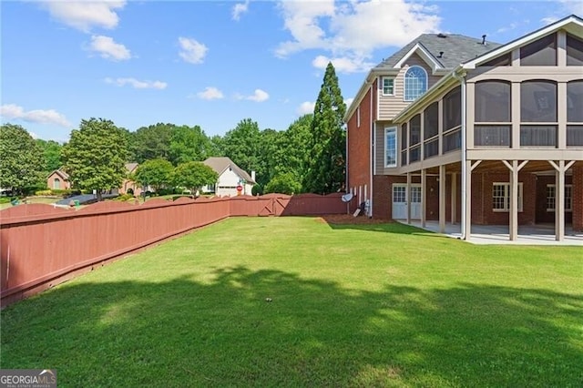 view of yard with a sunroom and a patio area