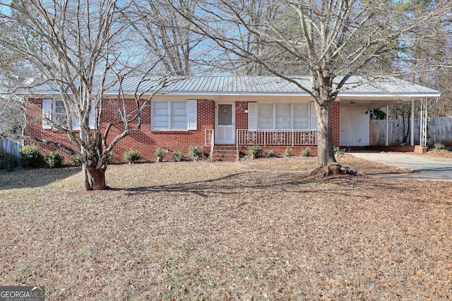 707 E Spring St, Monroe, GA 30655 - ranch-style home with fence, brick siding, a carport, concrete driveway, and metal roof