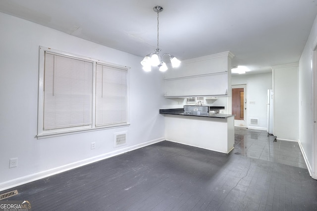 707 E Spring St, Monroe, GA 30655 - kitchen with a chandelier, a peninsula, dark countertops, baseboards, and pendant lighting