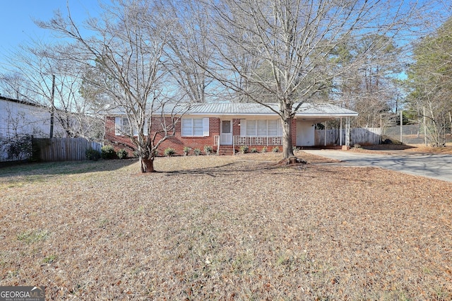 707 E Spring St, Monroe, GA 30655 - ranch-style house with driveway, fence, brick siding, and an attached carport