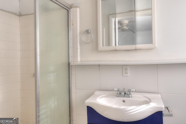 707 E Spring St, Monroe, GA 30655 - bathroom featuring a sink, a stall shower, tile walls, and a ceiling fan