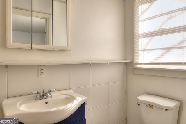 707 E Spring St, Monroe, GA 30655 - bathroom featuring a sink, toilet, and tile walls