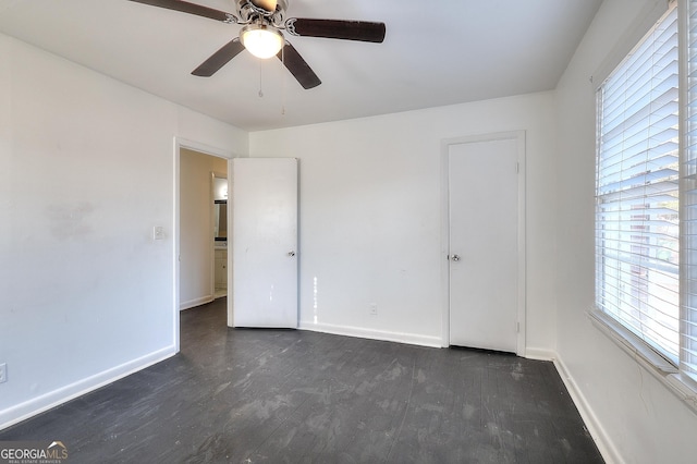 707 E Spring St, Monroe, GA 30655 - unfurnished bedroom featuring dark wood-style floors, baseboards, and a ceiling fan