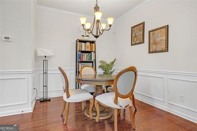 5711 Keys Way, Lithonia, GA 30058 - dining room with a chandelier, a decorative wall, crown molding, wood finished floors, and a wainscoted wall