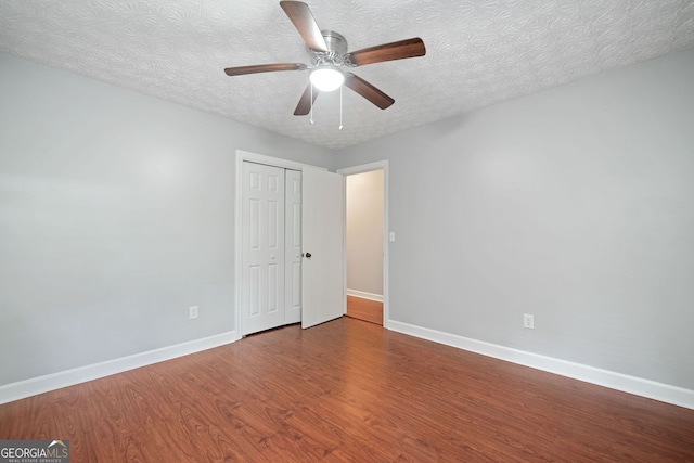 175 River Run, Roswell, GA 30075 - unfurnished bedroom featuring baseboards, wood finished floors, a closet, a textured ceiling, and ceiling fan