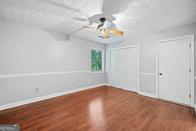 175 River Run, Roswell, GA 30075 - unfurnished bedroom with wood finished floors, baseboards, ceiling fan, and a textured ceiling