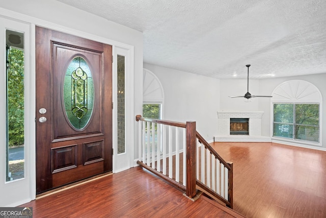 175 River Run, Roswell, GA 30075 - entrance foyer with wood finished floors, a textured ceiling, a ceiling fan, healthy amount of natural light, and a brick fireplace