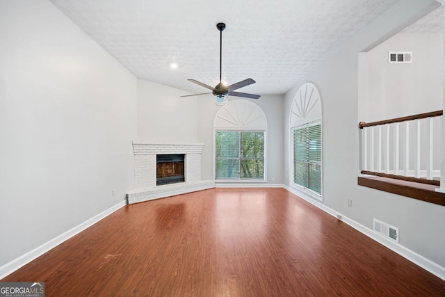 175 River Run, Roswell, GA 30075 - unfurnished living room featuring wood finished floors, baseboards, a textured ceiling, a ceiling fan, and a fireplace