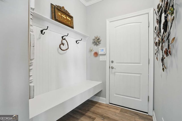 mudroom with ornamental molding and wood finished floors