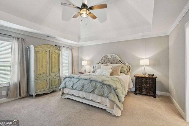bedroom with a raised ceiling, multiple windows, light colored carpet, and ornamental molding
