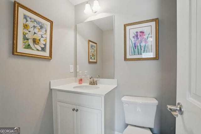 half bathroom featuring vanity and toilet