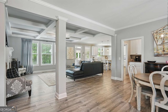 living room with light wood finished floors, coffered ceiling, baseboards, beam ceiling, and crown molding