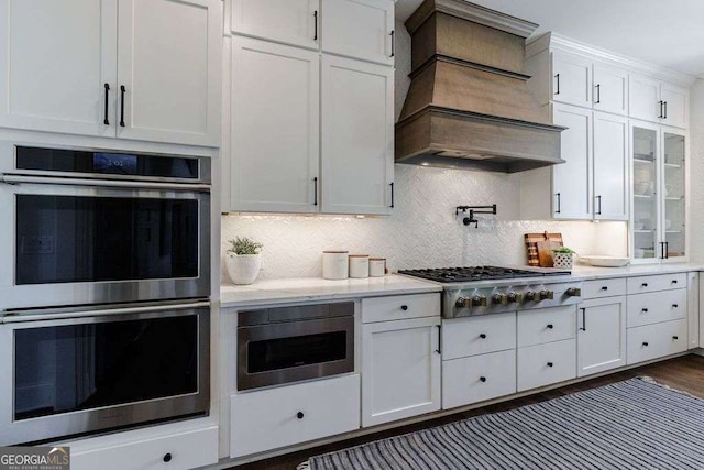 4992 Concert Ln, Marietta, GA 30066 - kitchen with appliances with stainless steel finishes, premium range hood, white cabinetry, and backsplash
