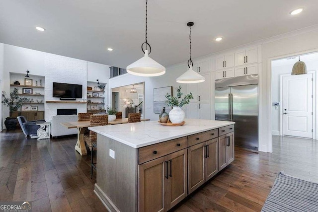 4992 Concert Ln, Marietta, GA 30066 - kitchen featuring built in fridge, dark wood-type flooring, a kitchen island, pendant lighting, and a kitchen breakfast bar