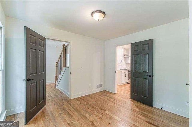 418 Mockingbird Ln, Smyrna, GA 30082 - spare room featuring stairway, baseboards, and light wood-style flooring