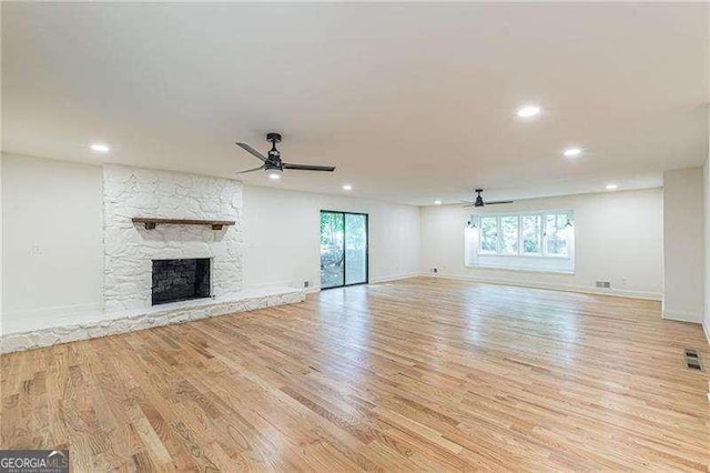 418 Mockingbird Ln, Smyrna, GA 30082 - unfurnished living room with a ceiling fan, light wood-type flooring, a stone fireplace, recessed lighting, and baseboards