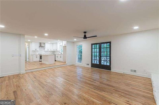 418 Mockingbird Ln, Smyrna, GA 30082 - unfurnished living room with french doors, light wood-type flooring, recessed lighting, ceiling fan, and baseboards