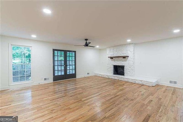 418 Mockingbird Ln, Smyrna, GA 30082 - unfurnished living room featuring wood finished floors, recessed lighting, a ceiling fan, a stone fireplace, and french doors