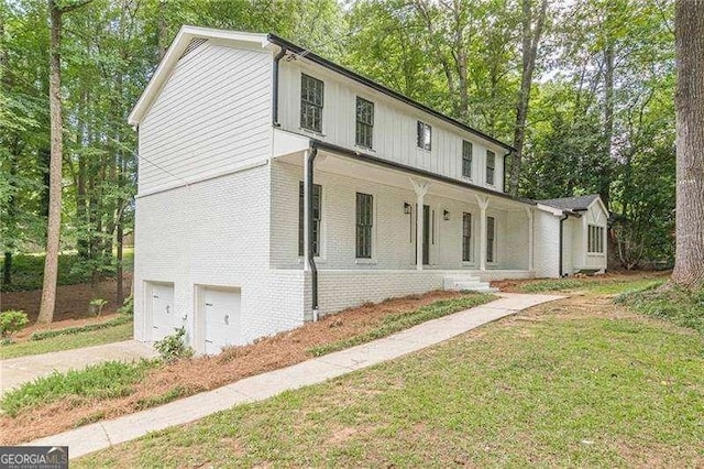 418 Mockingbird Ln, Smyrna, GA 30082 - modern farmhouse style home featuring brick siding, an attached garage, concrete driveway, a porch, and a front yard