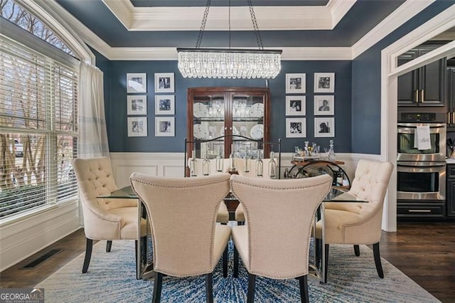 1525 Camden Cove Dr, Cumming, GA 30040 - dining space featuring a tray ceiling, a chandelier, ornamental molding, wainscoting, and wood finished floors
