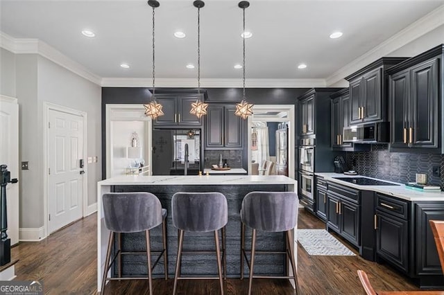 1525 Camden Cove Dr, Cumming, GA 30040 - kitchen featuring appliances with stainless steel finishes, an island with sink, backsplash, dark cabinetry, and recessed lighting