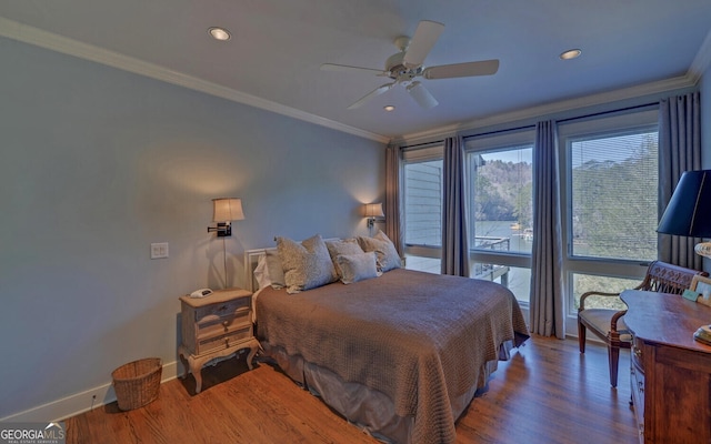 bedroom with baseboards, crown molding, wood finished floors, recessed lighting, and a ceiling fan