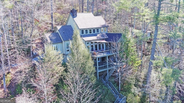 aerial view of property and surrounding area featuring a forest