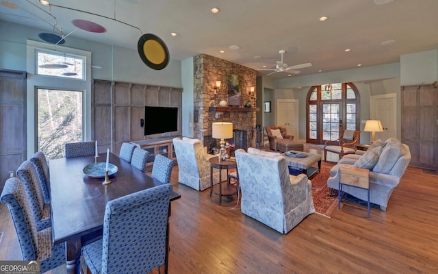 living room featuring wood finished floors, arched walkways, a fireplace, ceiling fan, and recessed lighting