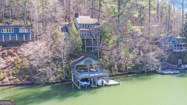 dock area featuring a water view, a gazebo, and a forest view