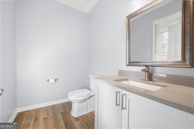3826 Baxley Village Trl, Suwanee, GA 30024 - bathroom with wood finished floors, toilet, vanity, baseboards, and vaulted ceiling