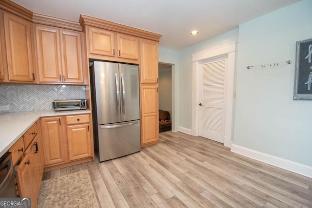 kitchen featuring appliances with stainless steel finishes, baseboards, light countertops, tasteful backsplash, and light wood-type flooring