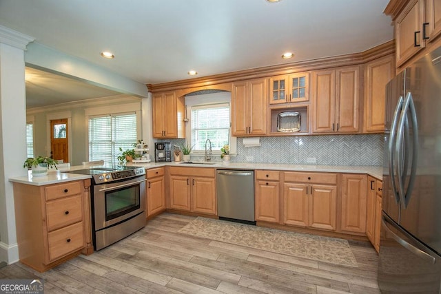 kitchen with appliances with stainless steel finishes, a sink, light wood-type flooring, light countertops, and recessed lighting