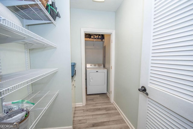 washroom with washer / dryer, wood finished floors, and baseboards