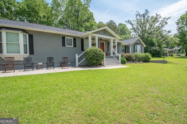 view of front of house featuring a front lawn, a porch, and a patio area