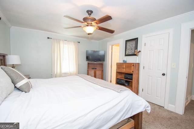 carpeted bedroom featuring ornamental molding, ceiling fan, and baseboards