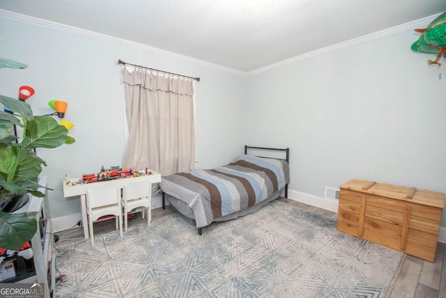 bedroom featuring ornamental molding, wood finished floors, and baseboards