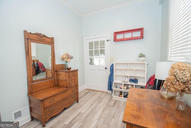 living area with light wood-style floors, ornamental molding, and baseboards