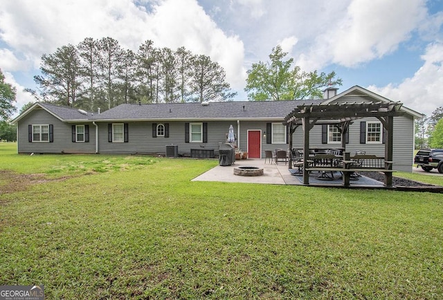 rear view of property with a pergola, a fire pit, a patio area, and a lawn