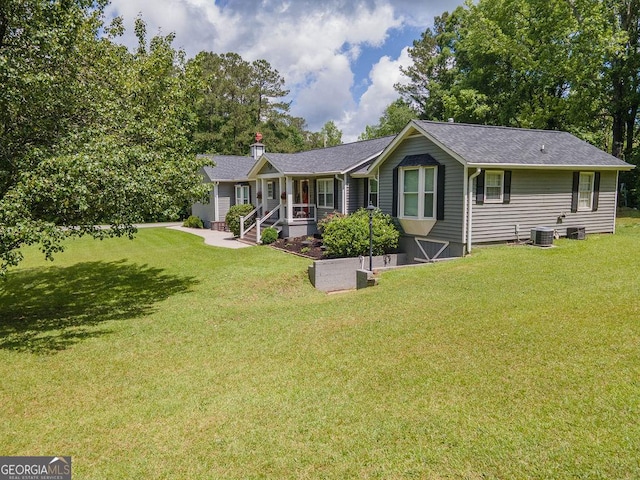 ranch-style home with central AC unit, a front lawn, roof with shingles, and a chimney