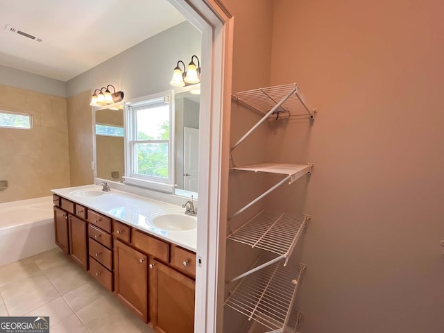 bathroom with tile patterned floors, double vanity, and a tub