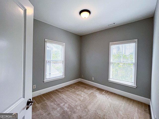 carpeted empty room with baseboards