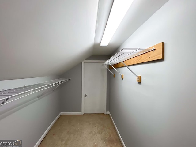 walk in closet featuring vaulted ceiling and light carpet