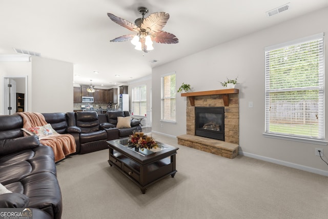 1181 Gateview Dr, Lawrenceville, GA 30046 - living room featuring ceiling fan, a stone fireplace, baseboards, and light colored carpet