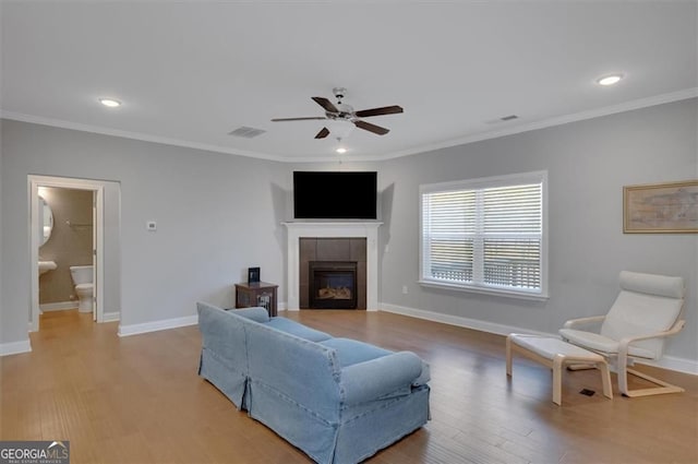541 Glen Abbey Cir, Mableton, GA 30126 - living area with a ceiling fan, a tiled fireplace, light wood-style floors, baseboards, and crown molding