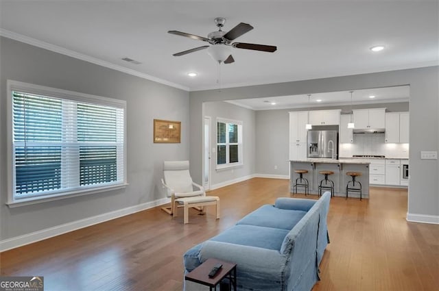 541 Glen Abbey Cir, Mableton, GA 30126 - living room with crown molding, light wood-type flooring, a ceiling fan, baseboards, and recessed lighting