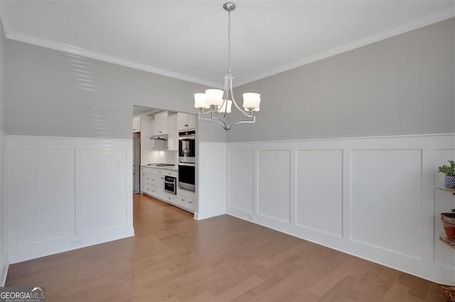 541 Glen Abbey Cir, Mableton, GA 30126 - unfurnished dining area featuring a decorative wall, a chandelier, ornamental molding, wainscoting, and wood finished floors
